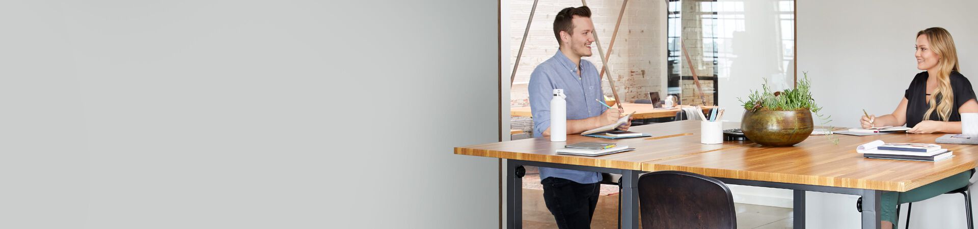 three coworkers collaborate in a conference room comprised of Vari products